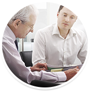 Young Man and Older Professional Man Discussing Documents in Office