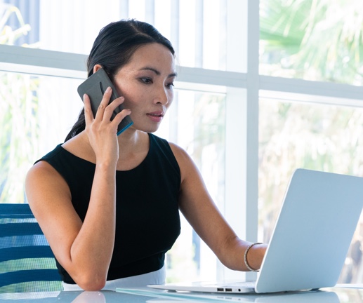 Woman using a laptop and speaking on the phone