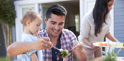 Husband and wife sitting down to lunch with baby daughter